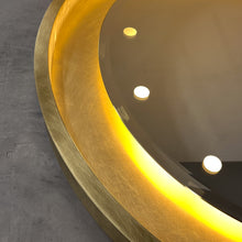 Special edition bevelled Orbis™ round mirror with a floating reflective surface, exquisite handcrafted brushed brass frame and bespoke illumination.