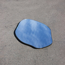 Modern freeform organic shaped mirror with a minimalist brass frame with a bronze patina finish