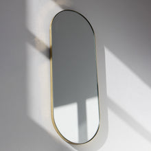 Capsula™ Capsule shaped Modern Mirror with an Elegant Brass Frame