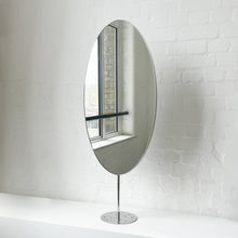 Countertop attached oval mirror with a modern stainless steel frame