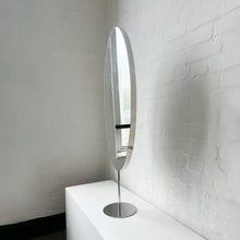 Countertop attached oval mirror with a modern stainless steel frame