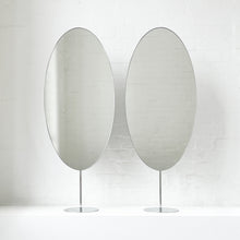 Countertop attached oval mirrors with a modern stainless steel frame