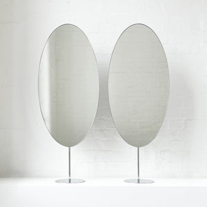Countertop attached oval mirrors with a modern stainless steel frame