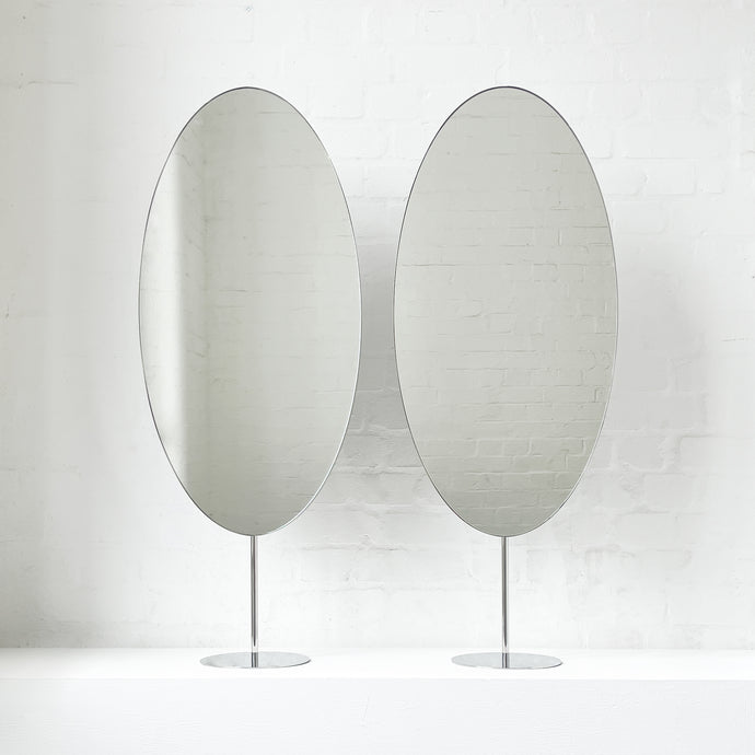 Countertop attached oval mirrors with a modern stainless steel frame