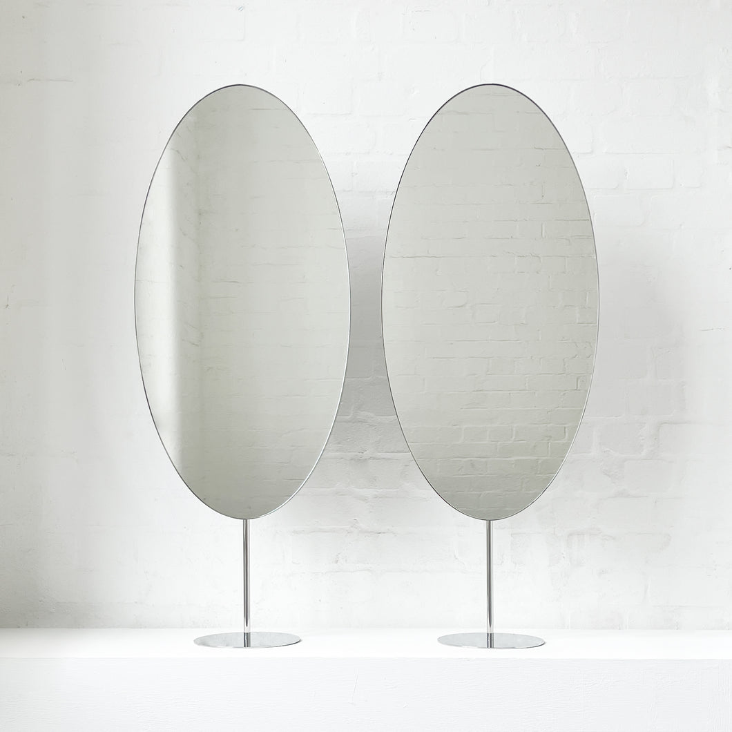Countertop attached oval mirrors with a modern stainless steel frame