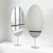 Countertop attached oval mirrors with a modern stainless steel frame