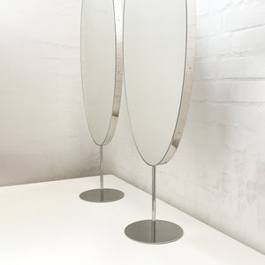Countertop attached oval mirrors with a modern stainless steel frame