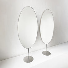 Countertop attached oval mirrors with a modern stainless steel frame