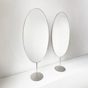 Countertop attached oval mirrors with a modern stainless steel frame