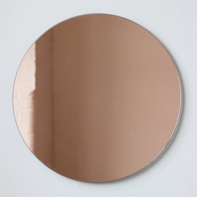 rose gold tinted frameless Orbis™ round mirror with a floating effect